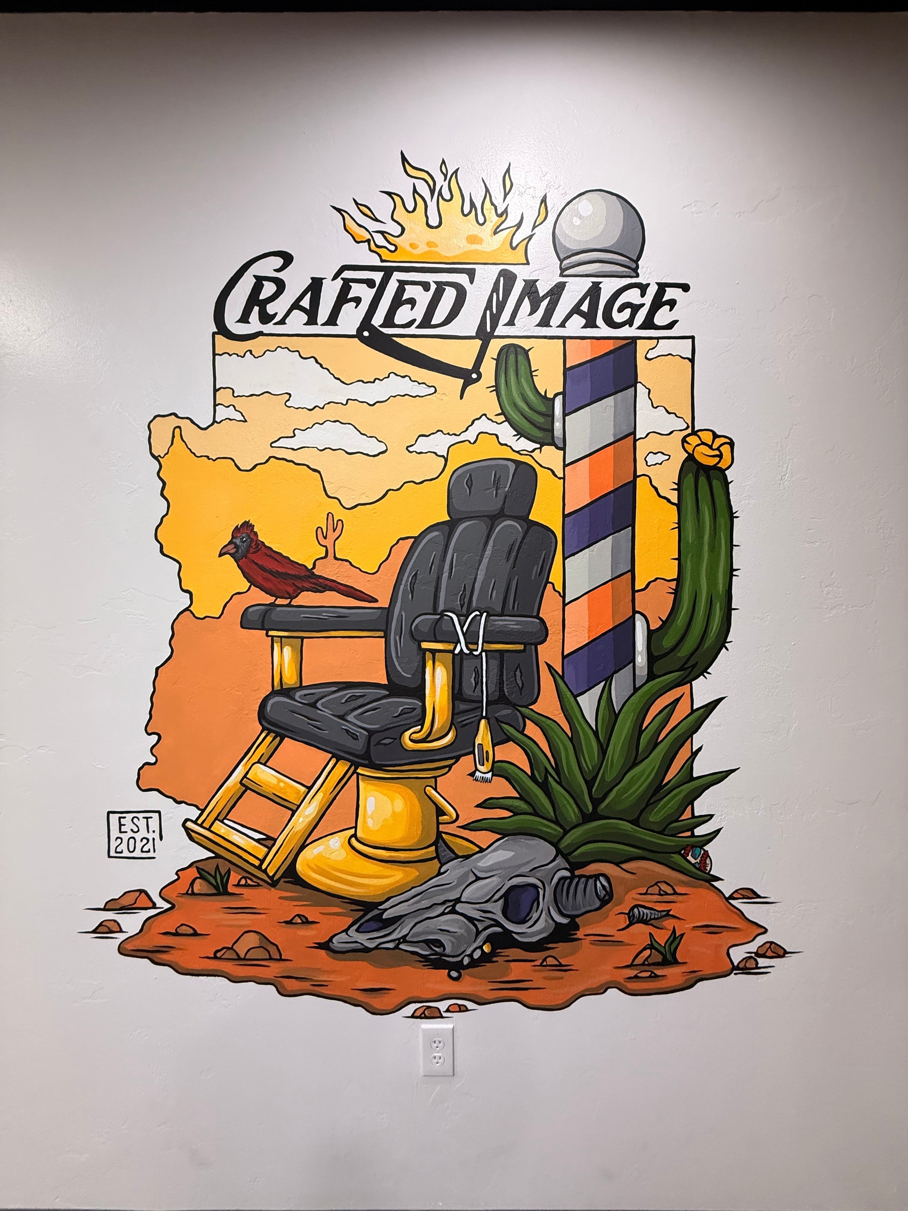 Hand-painted Arizona-themed mural for Crafted Image featuring a vintage barber chair, desert landscape, cactus, cardinal, barber pole, agave plant, and animal skull, with the Crafted Image logo integrated into the artwork.